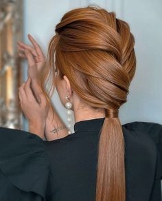 a woman with long red hair in a ponytail