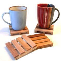 wooden coasters with two mugs on them, one is red and the other is blue