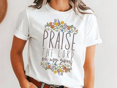 a woman wearing a white t - shirt that says praise the lord in my soul