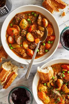 two bowls of stew and bread on a marble table