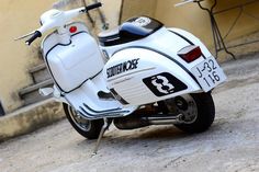 a white motor scooter parked on the street