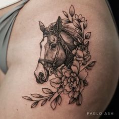 a woman's stomach with a horse and flowers tattoo on the side of her belly