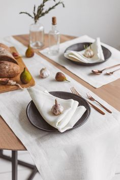 the table is set with plates, silverware and napkins for two people to eat