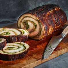 sliced meatloaf on wooden cutting board with knife