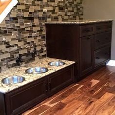 a kitchen with wooden floors and granite counter tops