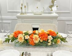 an arrangement of orange and white flowers on a table