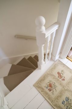 a stair case next to a rug on the floor