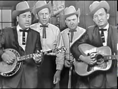 the three men are wearing hats and holding guitars in front of each other while singing