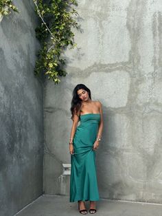 Emerald Waters Strapless Maxi Dress Dive into the deep allure of the coast with this silky emerald green maxi dress. The strapless design is elevated by subtle, pleated detailing across the bodice, creating a perfect blend of elegance and ease. Whether you're walking on the sand or dancing under the stars, this dress f Green Ruched Maxi Dress For Gala, Green Strapless Dress With Straight Neckline For Evening, Green Ruched Evening Maxi Dress, Green Prom Dress With Straight Neckline, Green Straight Neckline Dress For Prom, Green Strapless Maxi Dress For Night Out, Green Satin Maxi Dress For Gala, Green Maxi Dress For Gala And Prom Season, Green Ruched Maxi Dress For Prom