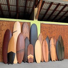 many surfboards are lined up against the wall