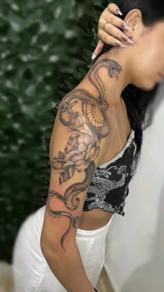 a woman with a snake tattoo on her arm