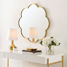 a white table with two lamps and a mirror on the wall next to it,