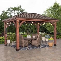 a wooden gazebo sitting on top of a patio next to a table and chairs