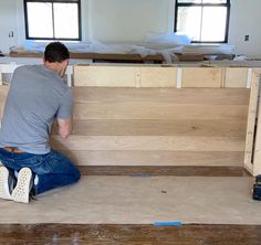 a man sitting on the floor working on some furniture