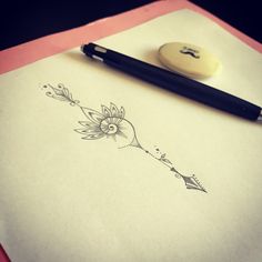 a pen sitting on top of a piece of paper next to a stamp with a flower