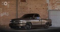 a silver truck parked in front of a brick building