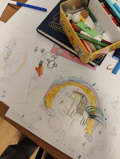 children's drawings and crayons are on the table