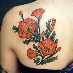 a woman's back tattoo with orange flowers