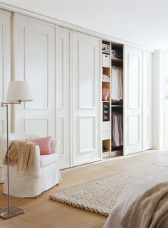 an empty bedroom with white closets and pink pillows