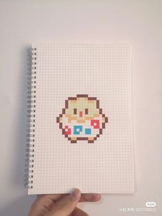 a hand holding a notebook with an image of a cupcake on it