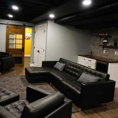 a living room filled with black leather furniture