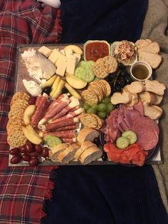 an assortment of cheeses, crackers, and meats on a platter