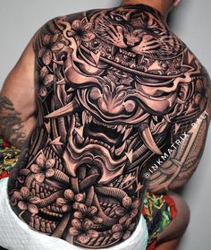 the back of a man's body covered in tattoos