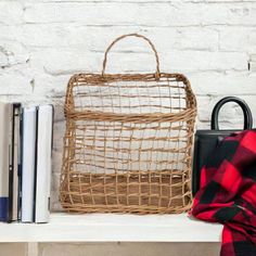 a basket sitting on top of a white shelf next to books and a book bag