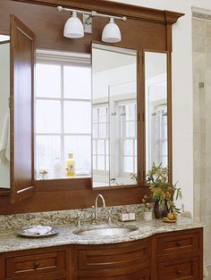 a bathroom with double sinks and large mirrors