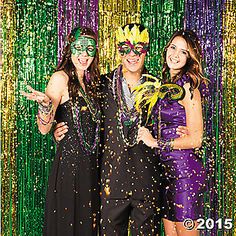 two women and a man standing in front of a photo booth with confetti