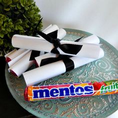 some white and black candy sticks are on a blue plate next to a potted plant