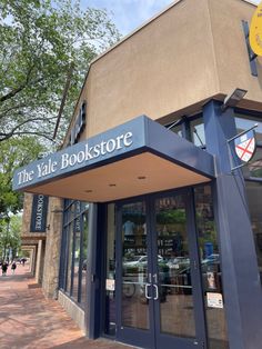 the front entrance to the book store is blue and has yellow signs that read,'the yale bookstore '