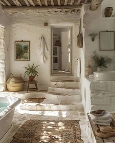 a bathroom with white walls and stone steps leading up to the bathtub in the corner