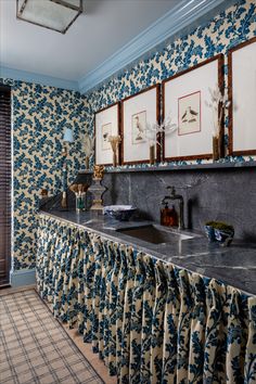 a bathroom with blue and white wallpaper and two sinks in the middle of the room