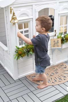 a little boy that is standing in front of a fake house