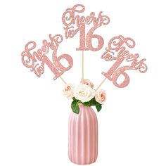 there is a pink vase with flowers in it and the number six on each cake topper