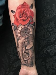 an elephant and rose tattoo on the arm