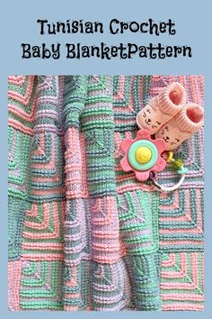 a crochet baby blanket with a pacifier and rattler on the top