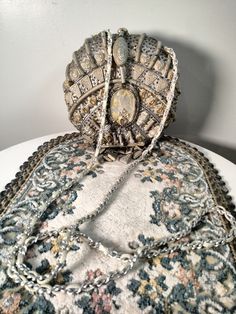 an old purse sitting on top of a white table next to a rug and wall