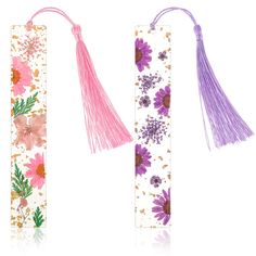 two bookmarks with flowers and tassels on them, one in pink and the other in purple