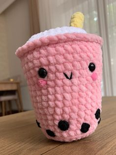 a crocheted coffee cup sitting on top of a wooden table