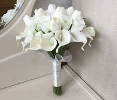 a bouquet of white flowers sitting on top of a counter