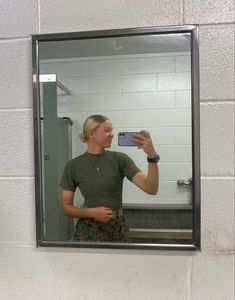 a woman taking a selfie in front of a mirror