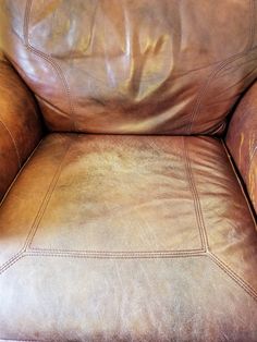 a brown leather chair that is sitting on the floor