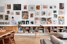 a living room filled with furniture and lots of pictures on the wall above it's bookshelf