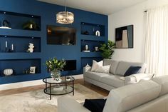 a living room with blue walls and white furniture