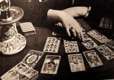 a woman sitting at a table with playing cards