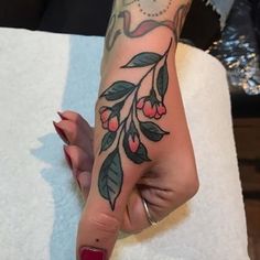 a woman's hand with a tattoo on it and a bird sitting on the branch