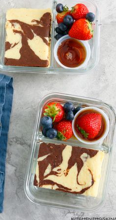 two desserts in plastic containers with fruit on the top and chocolate sauce on the bottom