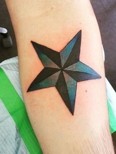 a black and blue star tattoo on the arm